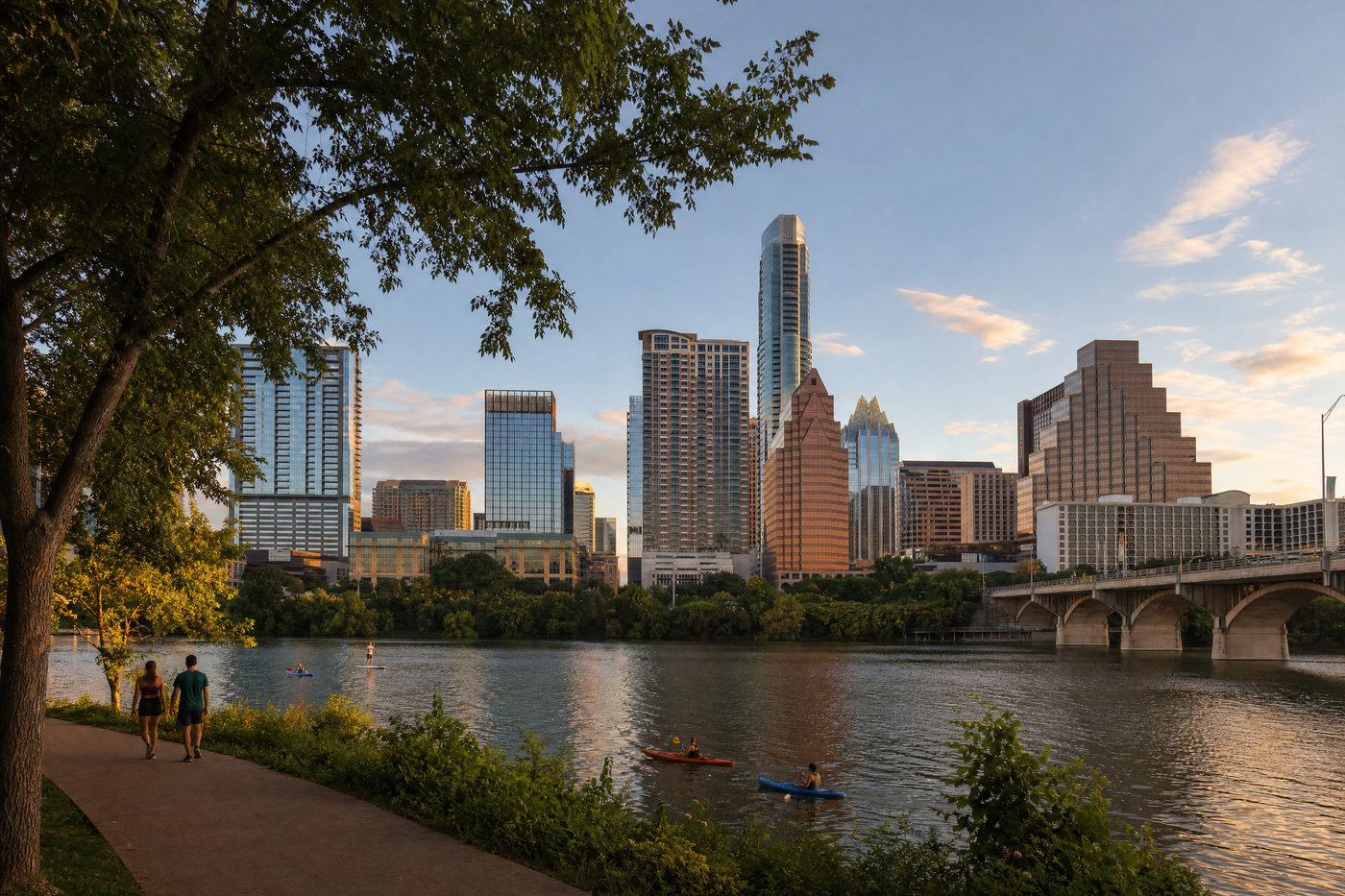 View of downtown Austin skyline with the Colorado River in the foreground at sunset.