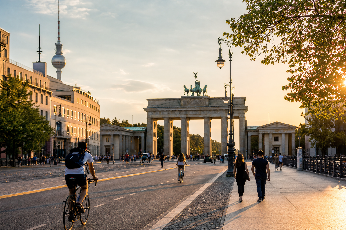 Panoramic view of Berlin cityscape with the Berlin TV Tower and Brandenburg Gate under blue sky.