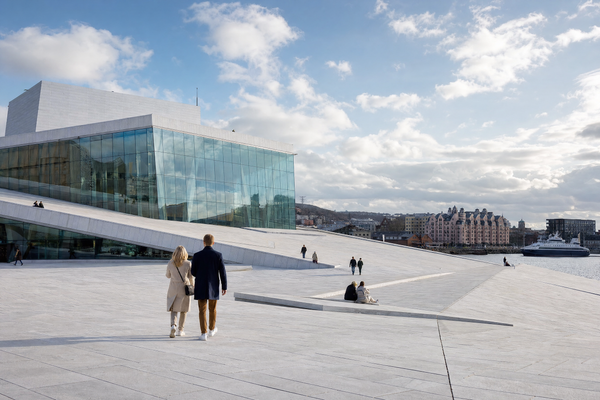 Oslo cityscape with harbor and fjord, sunlight highlighting seasonal beauty