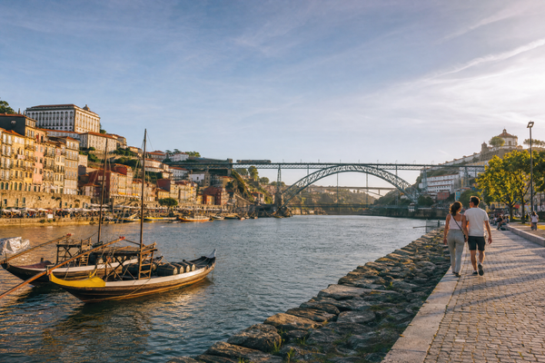 Colorful riverside buildings and the Douro River in Porto under clear skies.