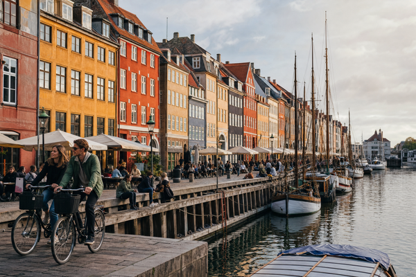 Quaint harbor houses lining Copenhagen’s Nyhavn canal under clear daytime skies