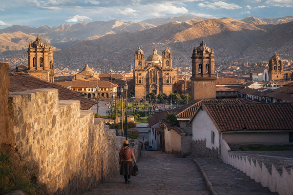 View of Cusco's Plaza de Armas and city rooftops with mountains in the background