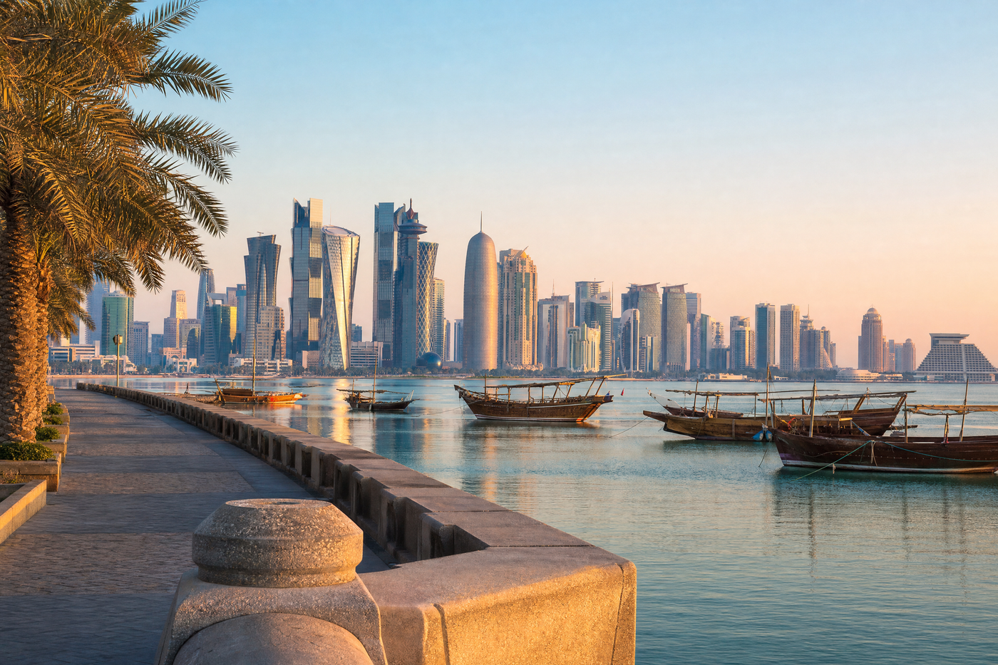Skyline of Doha at dusk with traditional dhow boats in the foreground