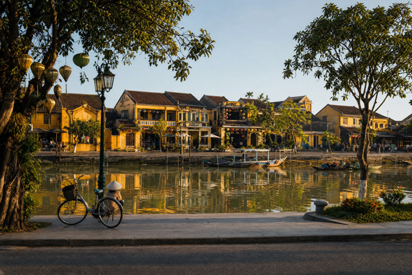Cyclists pass colorful lantern-lit streets in Hoi An Old Town, Vietnam