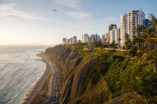 A panoramic view of Lima's Miraflores coastline with cliffs, parks, and the Pacific Ocean