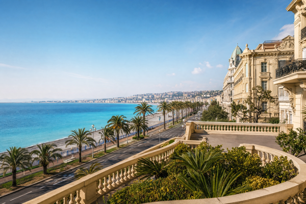 Panoramic view over Nice with colorful buildings, beach, palm trees and turquoise sea