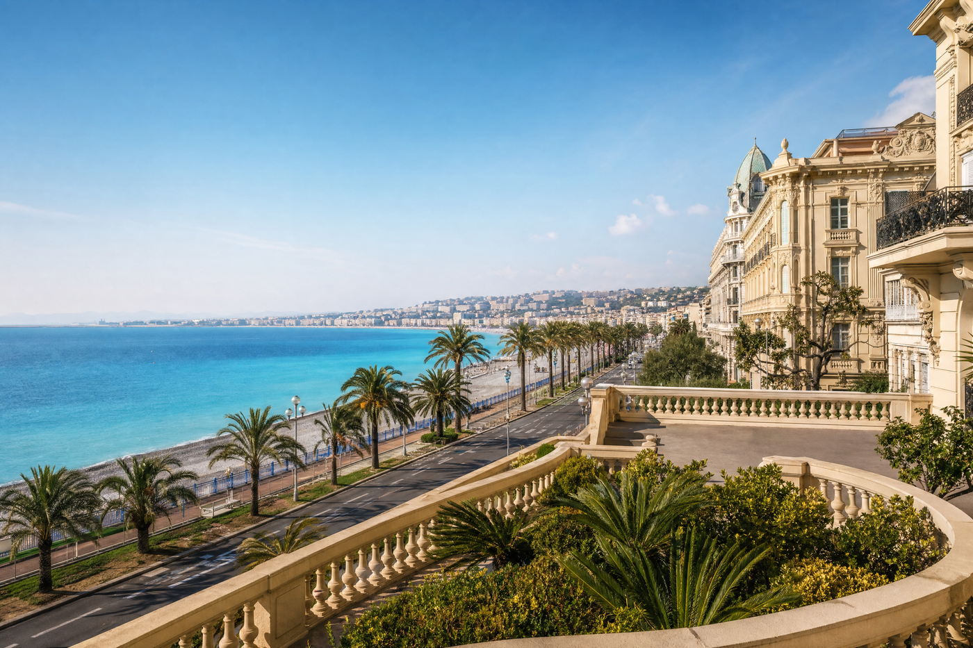 Panoramic view over Nice with colorful buildings, beach, palm trees and turquoise sea