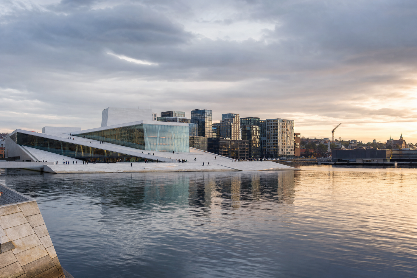 View of Oslo harbor and city buildings under a clear sky.