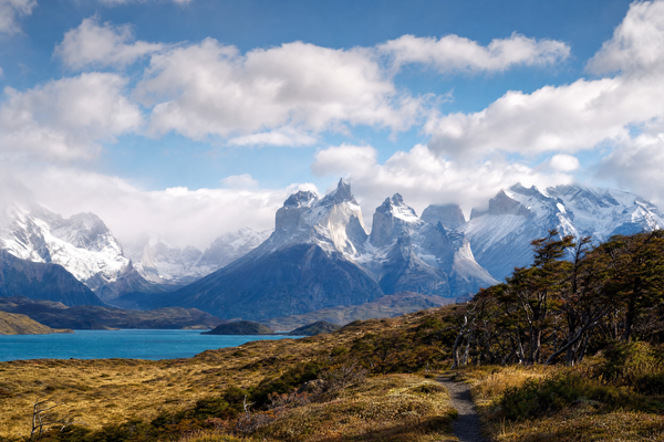 Jagged Patagonian peaks rising above blue lakes under soft morning light