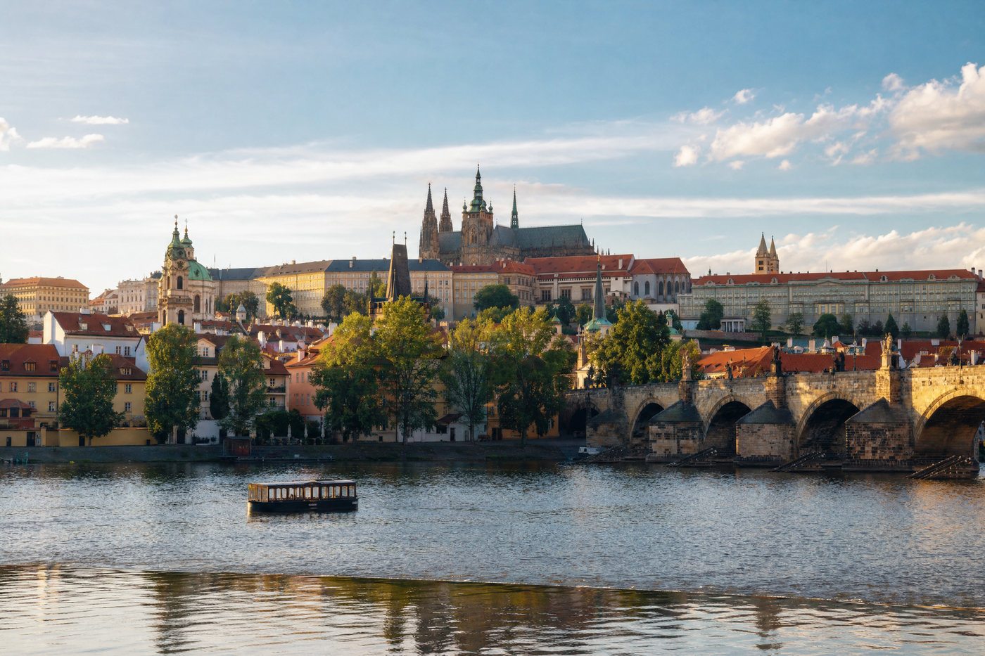 A panorama of Prague’s historic Old Town with Charles Bridge crossing the Vltava River at sunset