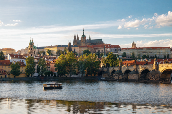 A panorama of Prague’s historic Old Town with Charles Bridge crossing the Vltava River at sunset