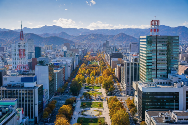 Sapporo’s Odori Park with city skyline and distant mountains