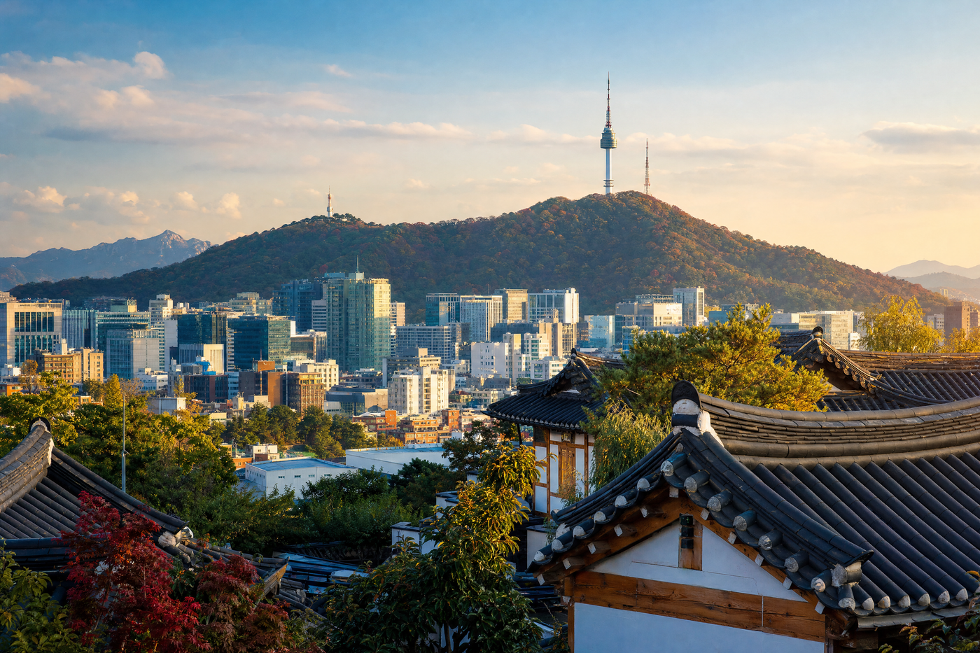 Traditional hanok rooftops with the modern Seoul skyline in the background