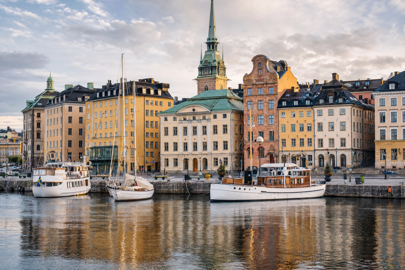 A scenic view of Stockholm’s colorful waterfront buildings and bridges under blue skies.