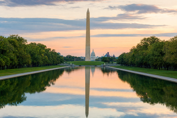 The National Mall in Washington DC with the Capitol and Washington Monument at sunset.