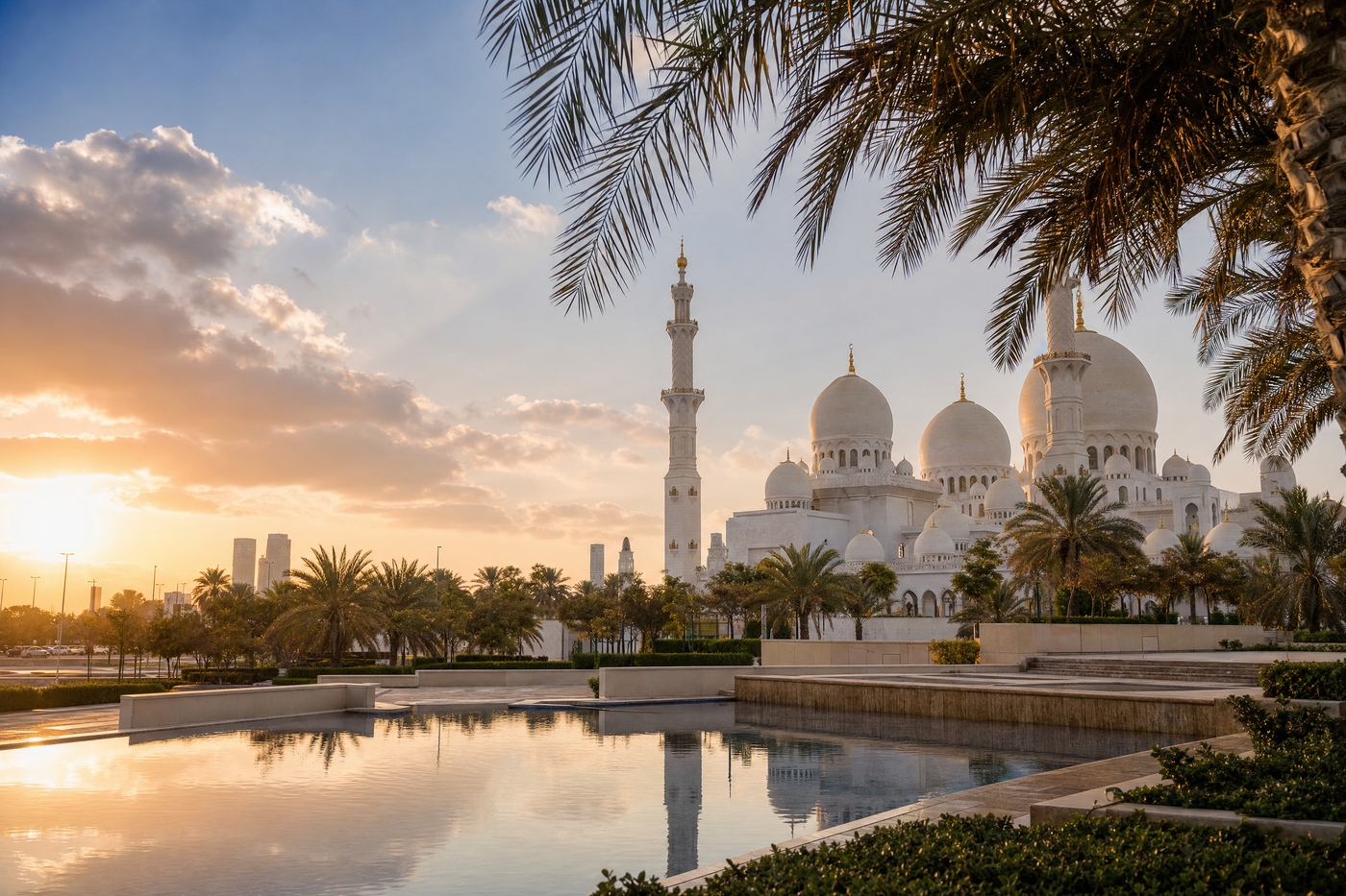 A panoramic view of Abu Dhabi with skyscrapers and vibrant districts along the coast at sunset.