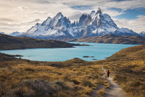 A panoramic view of Patagonian mountains, lakes, and a small town at sunrise