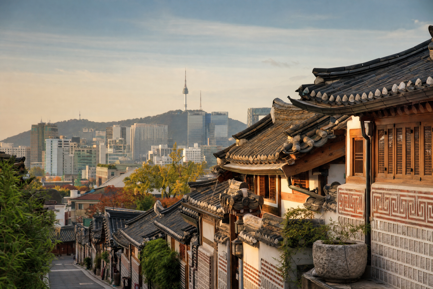 View of Seoul city with Namsan Tower and diverse neighborhoods in sunlight.